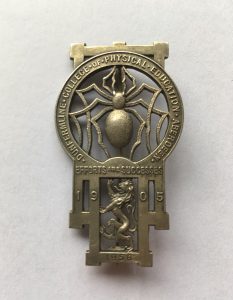 The Dunfermline College of Physical Education Brooch, featuring the spider, lion rampant, foundation date (1905) and the motto "Efforts are Successes". Image courtesy of Lorna M. Campbell