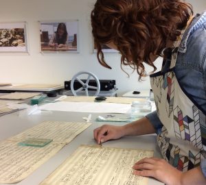 Book and paper conservation student, Lisa Behrens, carefully removing adhesive tape from the Forsaken Mermaid mansucript