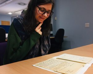 Archives cataloguing volunteer, Tara Copic, reading one of her favourite discoveries from the Patrick Geddes correspondence, a letter from Frank C. Mears to Patrick Geddes, 1908.