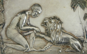 Detail from obverse, silver medal, Session 1913-1914, decorated with lion with raised paw being treated by kneeling figure, framed by palm trees and cliff
