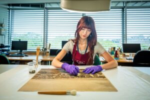 Blog writer sitting, cleaning on of the panorama plates using a small sponge. 