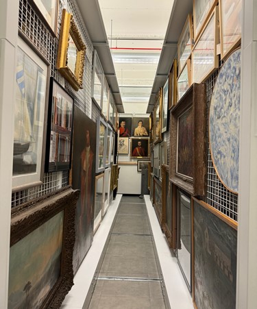 Image of various artworks hung on two walls facing opposite each other.