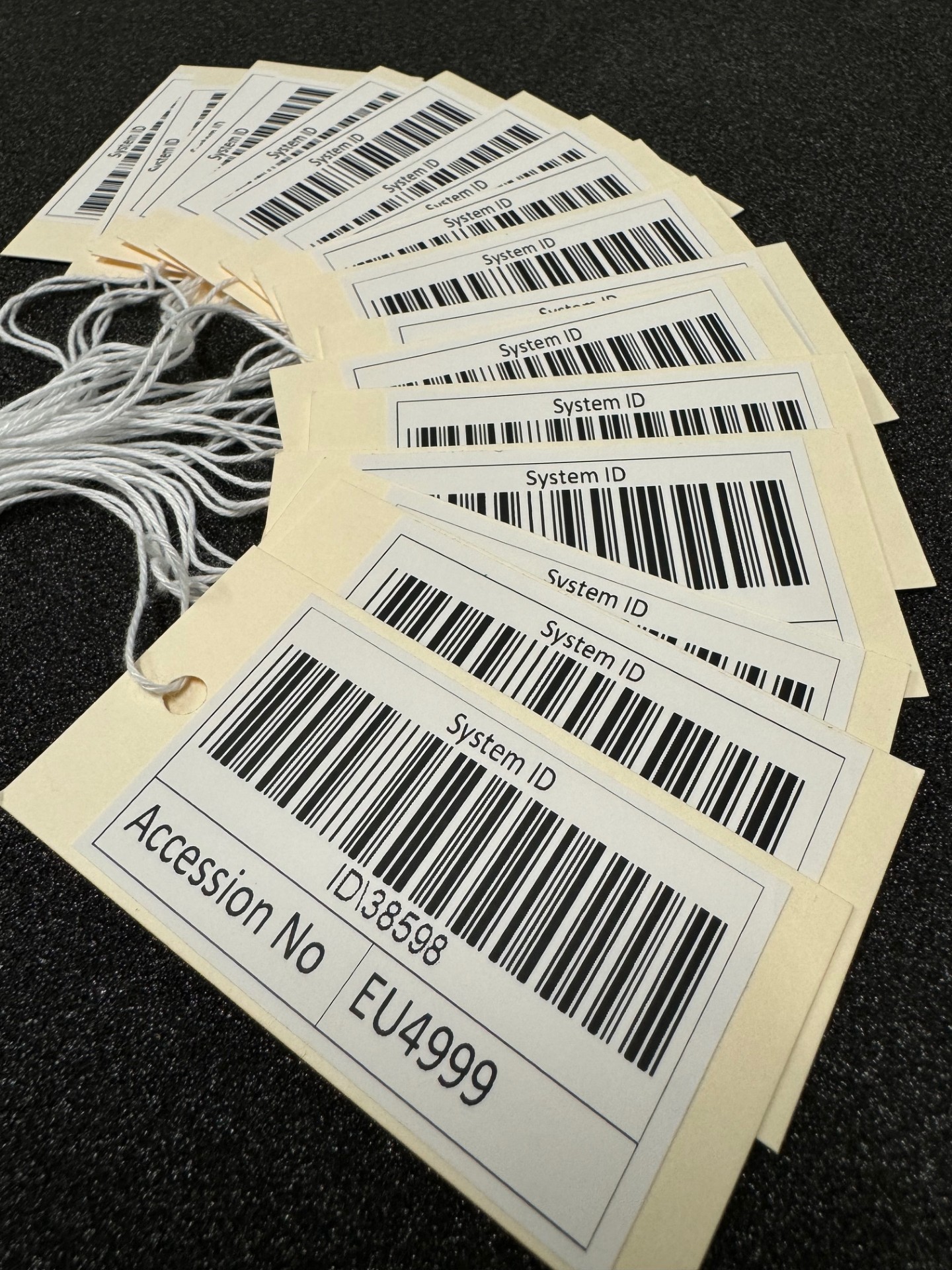 Group of labels fanned out on black background with barcodes printed on them.