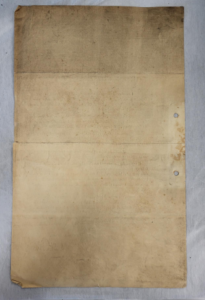 The backside of a foolscap sized page. It is off white and heavily stained with dust, dirt and soot.