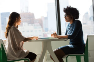 2 women talking at table