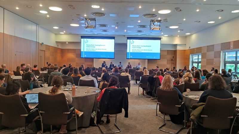 Photo of the Plenary panel discussion with attendees in the foreground.