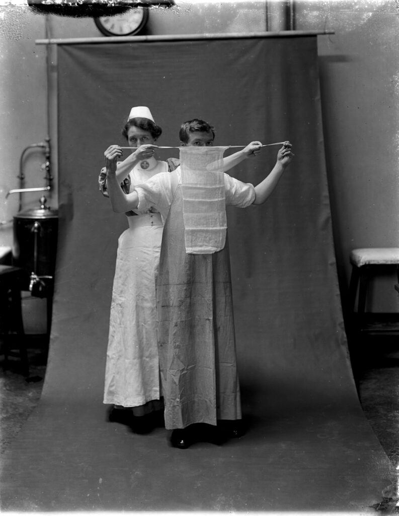 A photo of a nurse tying Sir Henry Gray’s surgical mask