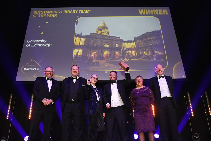 Members of the Library Research Support team receiving their award on stage.