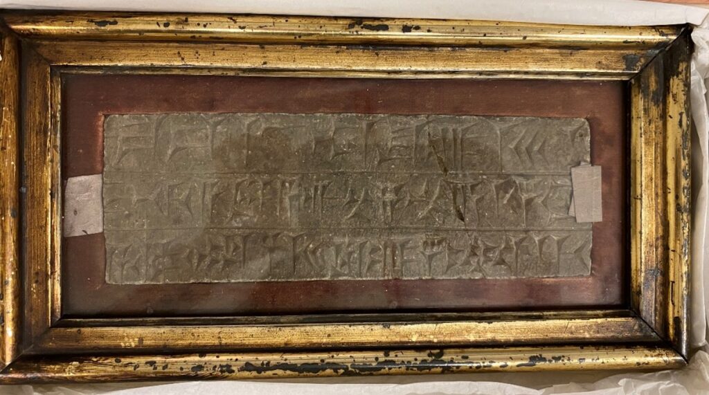 Cuneiform tablet text in a gold coloured picture frame