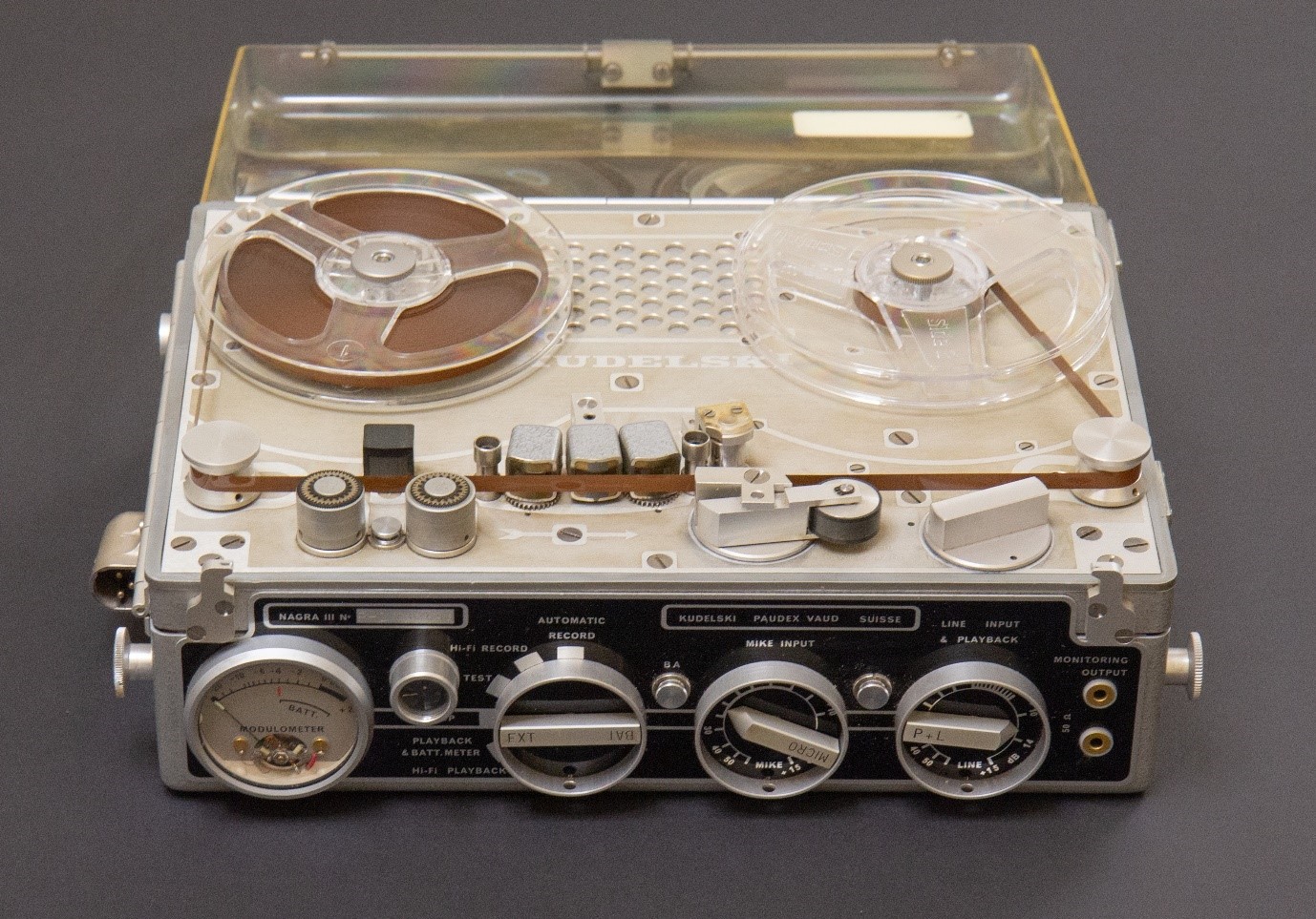 A nagra recorder. There are two reels on the top of the machine. On the front sde there are a series of dials