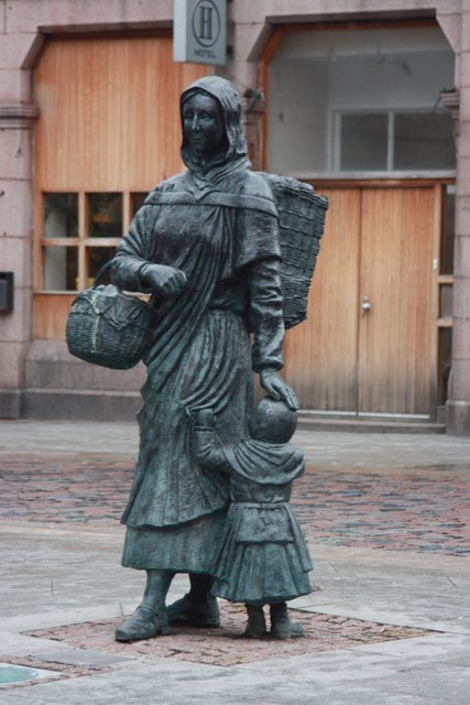 Photograph of the Fisher Jessie statue in Peterhead, Scotland. (A naturalistic bronze cast statue of a fish-wife and little girl, the woman carrying a creel and a basket.)
