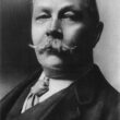 A black and white portrait photograph of Arthur Conan Doyle