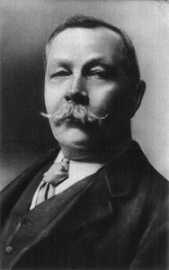 A black and white portrait photograph of Arthur Conan Doyle